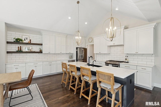 6925 Grover Sta, Bettendorf, IA 52722 - kitchen featuring stainless steel appliances, a chandelier, decorative backsplash, a center island with sink, and lofted ceiling