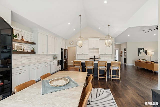 6925 Grover Sta, Bettendorf, IA 52722 - dining room with dark wood-type flooring, recessed lighting, a ceiling fan, and high vaulted ceiling