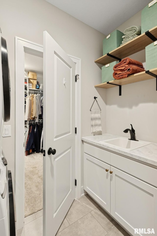 6925 Grover Sta, Bettendorf, IA 52722 - laundry room with light tile patterned flooring and cabinet space