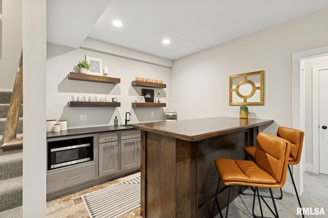 6925 Grover Sta, Bettendorf, IA 52722 - indoor wet bar featuring stainless steel microwave, recessed lighting, and stairway