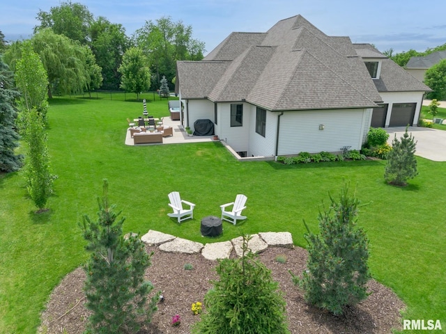 6925 Grover Sta, Bettendorf, IA 52722 - rear view of property with a patio, an outdoor living space with a fire pit, roof with shingles, concrete driveway, and an attached garage