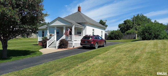 304 2nd St, Matherville, IL 61263 - view of front facade with covered porch, driveway, roof with shingles, a front lawn, and a chimney