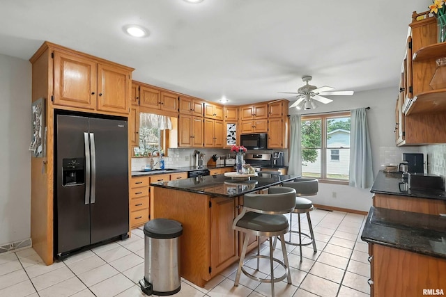 1020 Brown St, Bettendorf, IA 52722 - kitchen featuring stainless steel appliances, tasteful backsplash, a kitchen island, a ceiling fan, and recessed lighting