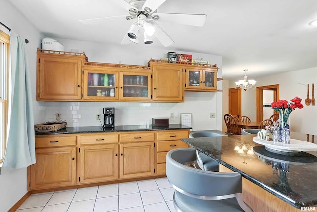 1020 Brown St, Bettendorf, IA 52722 - kitchen with backsplash, glass insert cabinets, a chandelier, light tile patterned flooring, and a ceiling fan