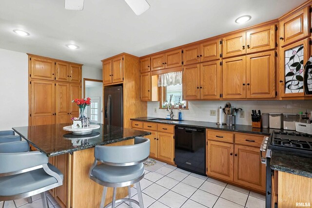 1020 Brown St, Bettendorf, IA 52722 - kitchen featuring black appliances, backsplash, a kitchen bar, brown cabinets, and recessed lighting