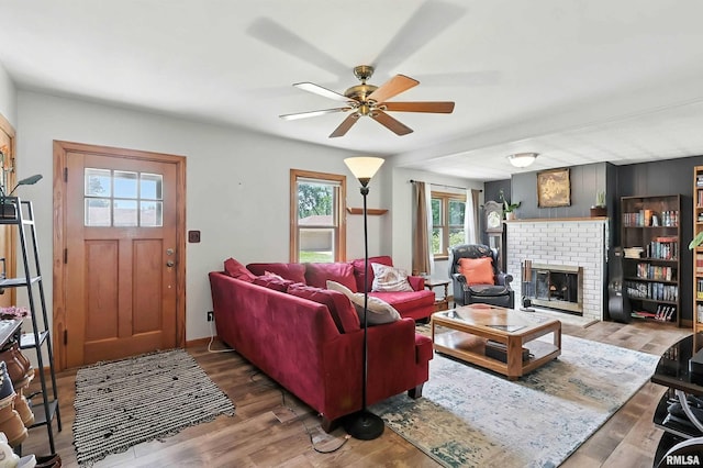 1020 Brown St, Bettendorf, IA 52722 - living room featuring ceiling fan, healthy amount of natural light, wood finished floors, and a brick fireplace