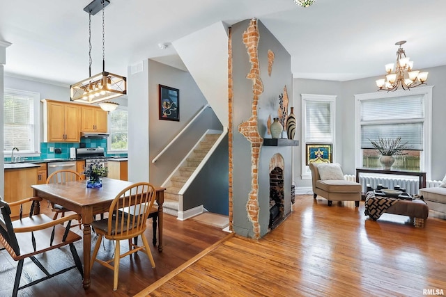 1703 20th St, Rock Island, IL 61201 - dining room with a chandelier, light wood finished floors, stairs, and a fireplace