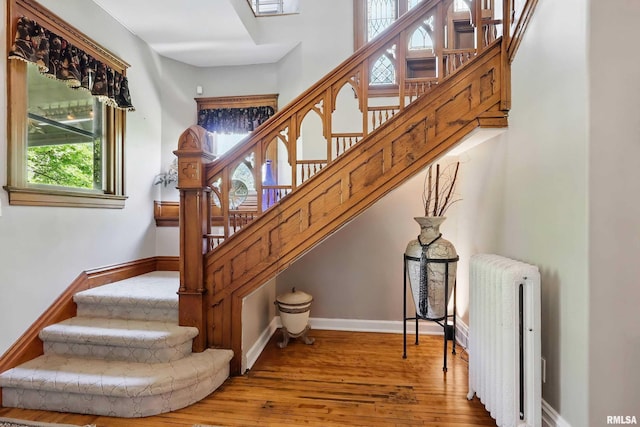 1703 20th St, Rock Island, IL 61201 - stairway featuring radiator heating unit and hardwood / wood-style floors
