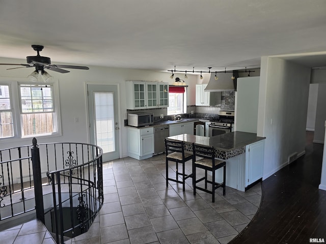 2505 Cody St, Bettendorf, IA 52722 - kitchen with stainless steel appliances, a breakfast bar area, dark countertops, and tasteful backsplash