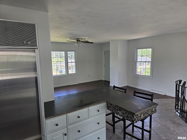 2505 Cody St, Bettendorf, IA 52722 - kitchen featuring high end fridge, white cabinetry, a ceiling fan, dark countertops, and open floor plan