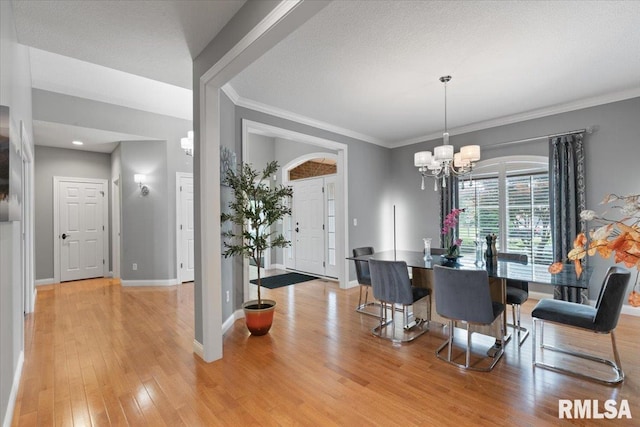 5985 Eagle Ridge Rd, Bettendorf, IA 52722 - dining space featuring light wood-type flooring, a chandelier, and crown molding