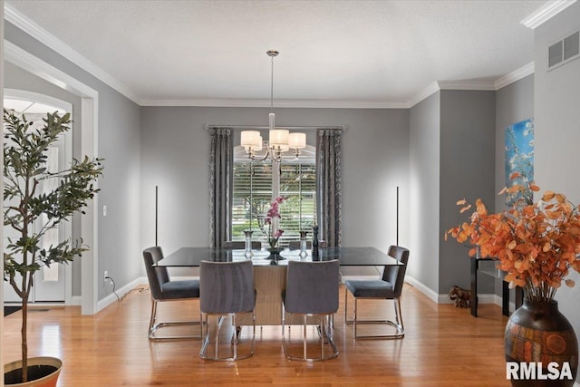5985 Eagle Ridge Rd, Bettendorf, IA 52722 - dining area with light wood finished floors, a chandelier, and crown molding