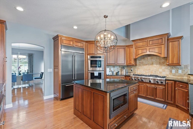 5985 Eagle Ridge Rd, Bettendorf, IA 52722 - kitchen with built in appliances, a chandelier, brown cabinetry, and recessed lighting
