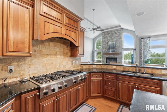 5985 Eagle Ridge Rd, Bettendorf, IA 52722 - kitchen with lofted ceiling, stainless steel gas cooktop, a ceiling fan, light wood finished floors, and tasteful backsplash