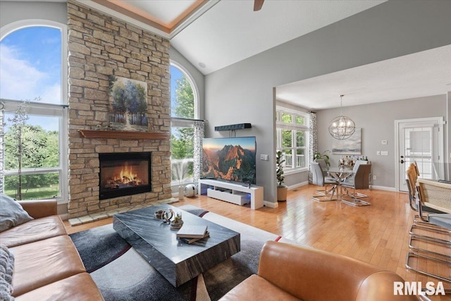 5985 Eagle Ridge Rd, Bettendorf, IA 52722 - living room with a chandelier, wood finished floors, a stone fireplace, and lofted ceiling
