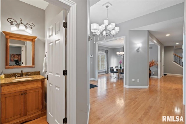 5985 Eagle Ridge Rd, Bettendorf, IA 52722 - bathroom featuring a chandelier, wood finished floors, and vanity