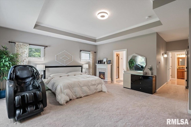 5985 Eagle Ridge Rd, Bettendorf, IA 52722 - carpeted bedroom featuring a tray ceiling, a glass covered fireplace, and ensuite bath