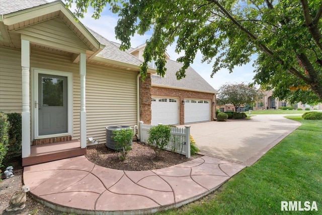 5985 Eagle Ridge Rd, Bettendorf, IA 52722 - view of side of home with a shingled roof, concrete driveway, an attached garage, and brick siding