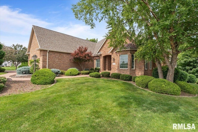 5985 Eagle Ridge Rd, Bettendorf, IA 52722 - view of front of home featuring brick siding, a front lawn, and a shingled roof