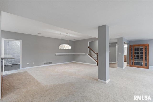5985 Eagle Ridge Rd, Bettendorf, IA 52722 - unfurnished living room featuring carpet flooring and stairs