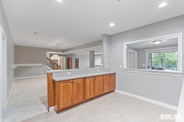 5985 Eagle Ridge Rd, Bettendorf, IA 52722 - kitchen with light countertops, brown cabinetry, a peninsula, open floor plan, and recessed lighting