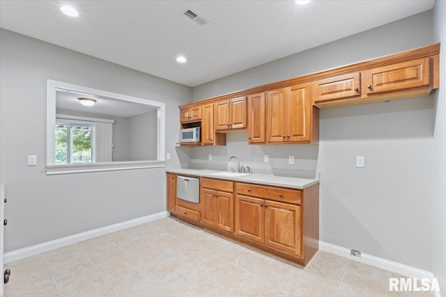 5985 Eagle Ridge Rd, Bettendorf, IA 52722 - kitchen with stainless steel microwave, light countertops, recessed lighting, brown cabinets, and dishwashing machine