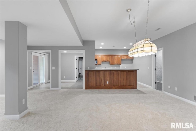 5985 Eagle Ridge Rd, Bettendorf, IA 52722 - kitchen featuring light colored carpet, decorative light fixtures, brown cabinets, recessed lighting, and open floor plan