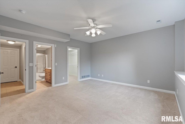 5985 Eagle Ridge Rd, Bettendorf, IA 52722 - unfurnished bedroom featuring light colored carpet, a spacious closet, a closet, and connected bathroom