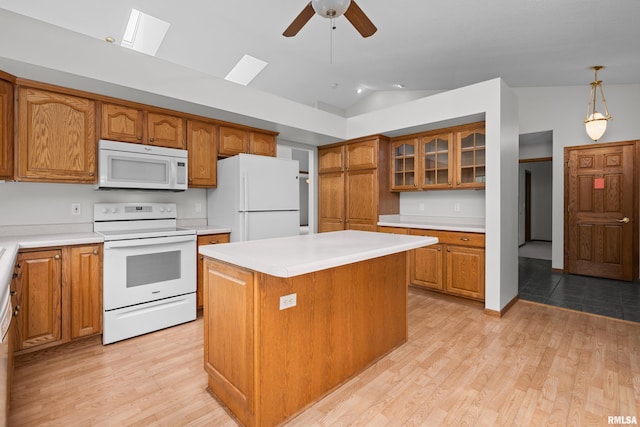10 Briarwood Ln Unit 10, Rock Island, IL 61201 - kitchen featuring white appliances, lofted ceiling, brown cabinetry, light countertops, and glass insert cabinets