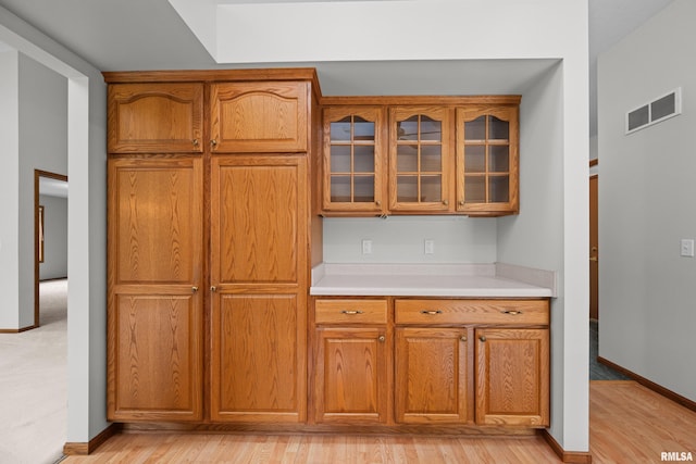 10 Briarwood Ln Unit 10, Rock Island, IL 61201 - kitchen with light countertops, glass insert cabinets, brown cabinets, and light wood finished floors