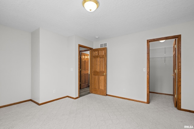 10 Briarwood Ln Unit 10, Rock Island, IL 61201 - unfurnished bedroom featuring carpet floors, a spacious closet, a closet, and a textured ceiling