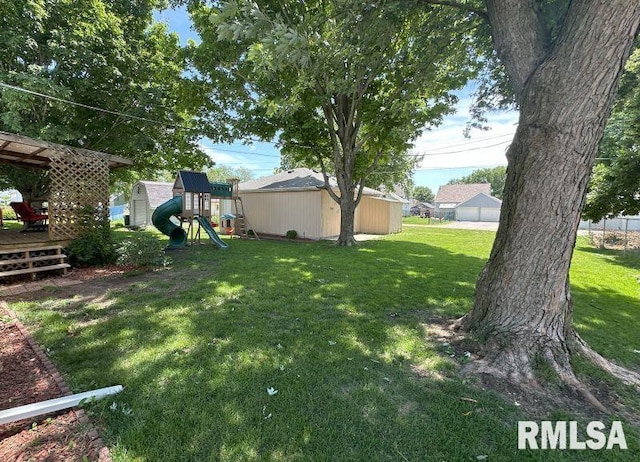 611 13th St, De Witt, IA 52742 - view of green lawn with a playground and a wooden deck