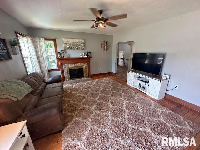 611 13th St, De Witt, IA 52742 - living room with wood finished floors, ceiling fan, arched walkways, and a glass covered fireplace