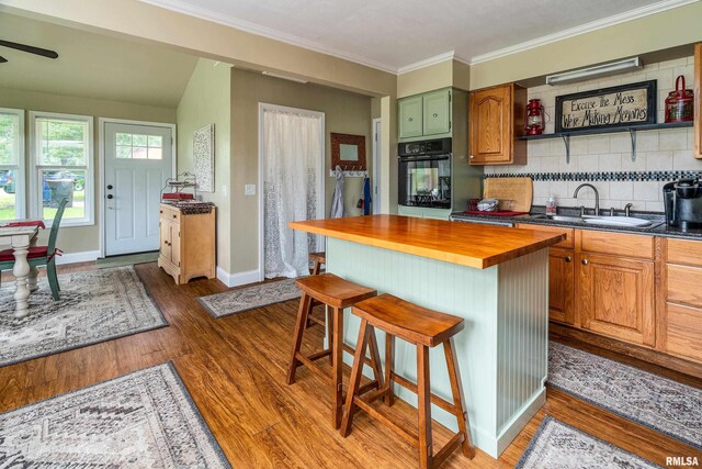1278 Nicklaus Ln, Marion, IL 62959 - kitchen with butcher block counters, black oven, dark wood-style flooring, a kitchen breakfast bar, and ornamental molding