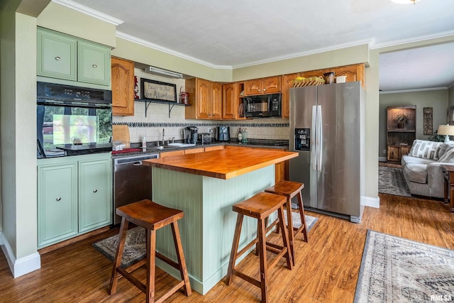 1278 Nicklaus Ln, Marion, IL 62959 - kitchen with black appliances, butcher block countertops, ornamental molding, light wood-type flooring, and decorative backsplash