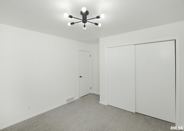 3503 36th St, Moline, IL 61265 - unfurnished bedroom featuring a chandelier, a closet, and light colored carpet