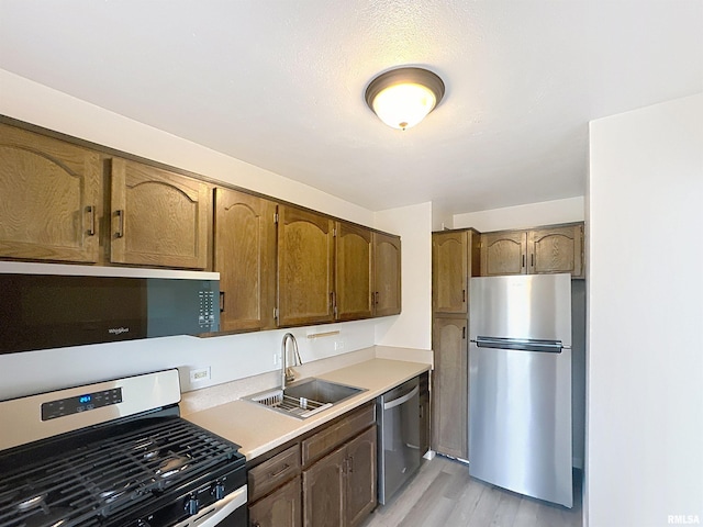 1800 7th St Unit 6D, East Moline, IL 61244 - kitchen featuring appliances with stainless steel finishes, light wood-style floors, light countertops, and brown cabinetry