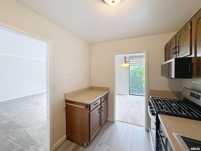 1800 7th St Unit 6D, East Moline, IL 61244 - kitchen featuring stainless steel gas range oven, light wood-type flooring, and light countertops