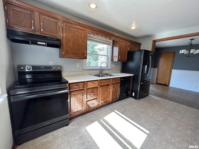 409 E Pearl St, Geneseo, IL 61254 - kitchen with black appliances, under cabinet range hood, light countertops, a chandelier, and recessed lighting