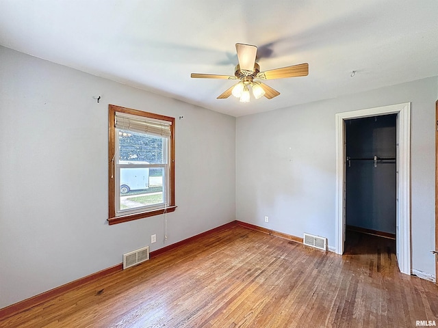 409 E Pearl St, Geneseo, IL 61254 - unfurnished bedroom featuring wood finished floors, a walk in closet, a closet, and ceiling fan