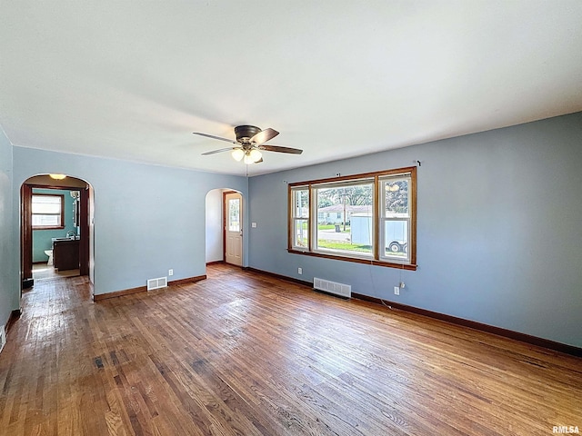 409 E Pearl St, Geneseo, IL 61254 - unfurnished room with arched walkways, wood finished floors, and a ceiling fan