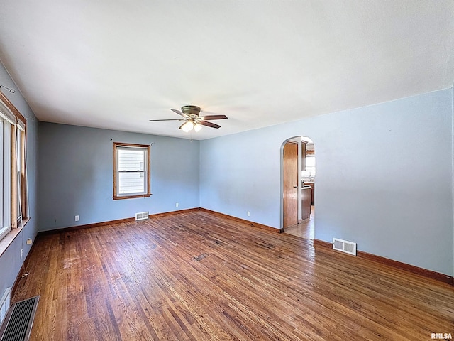409 E Pearl St, Geneseo, IL 61254 - empty room featuring arched walkways, ceiling fan, and wood finished floors