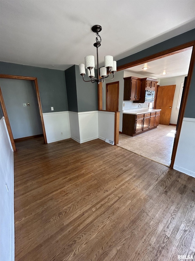 409 E Pearl St, Geneseo, IL 61254 - unfurnished dining area with a chandelier and wood finished floors