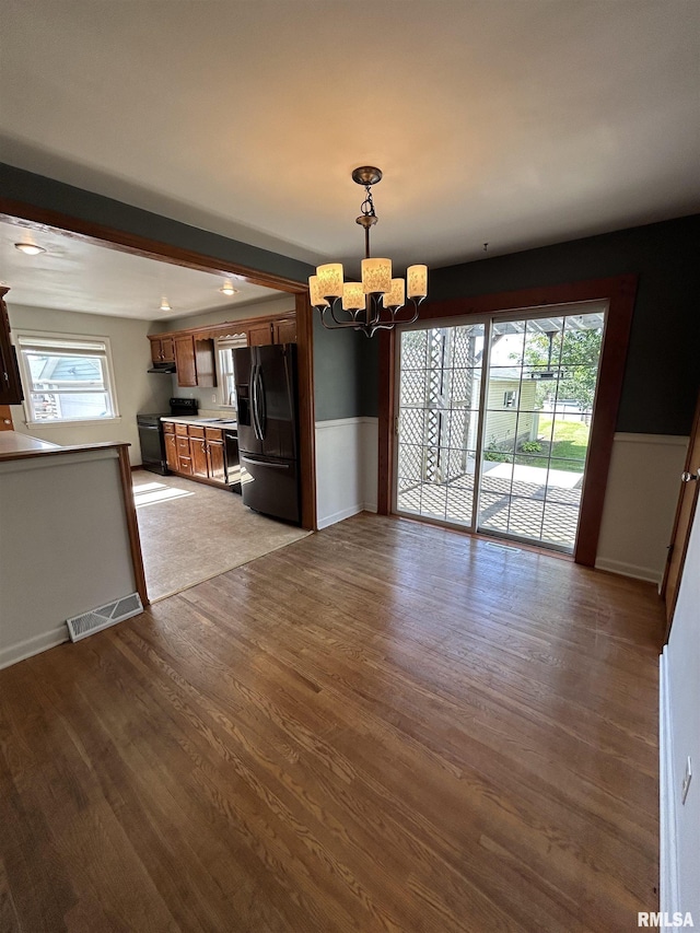 409 E Pearl St, Geneseo, IL 61254 - unfurnished dining area featuring a chandelier, wood finished floors, and plenty of natural light