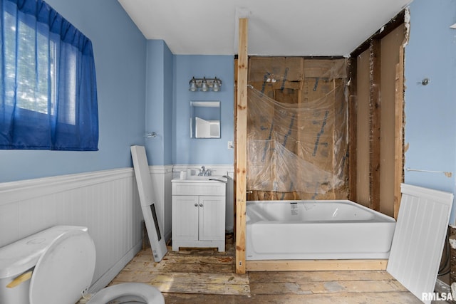 1312 Farnam St, Davenport, IA 52803 - full bath with a tub, wainscoting, vanity, and hardwood / wood-style flooring