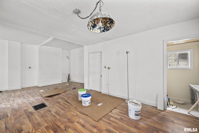 1312 Farnam St, Davenport, IA 52803 - unfurnished dining area with wood finished floors and a textured ceiling