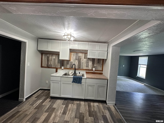1415 45th Ave, Rock Island, IL 61201 - kitchen featuring dark wood-style flooring, white cabinets, light countertops, and a textured ceiling