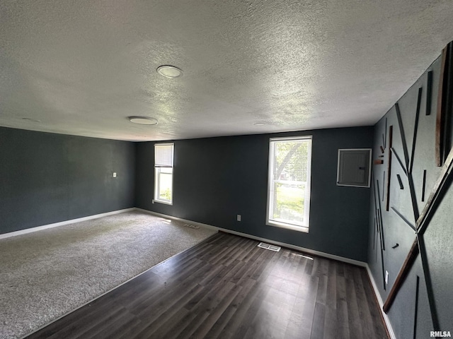 1415 45th Ave, Rock Island, IL 61201 - spare room featuring a textured ceiling, dark wood-type flooring, and electric panel