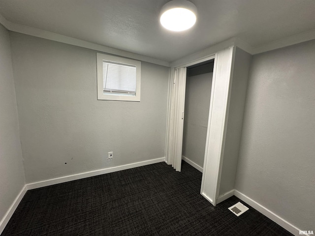 1415 45th Ave, Rock Island, IL 61201 - unfurnished bedroom featuring dark colored carpet and a closet