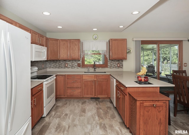 2035 N Gayman Ave, Davenport, IA 52804 - kitchen with white appliances, a peninsula, plenty of natural light, backsplash, and recessed lighting